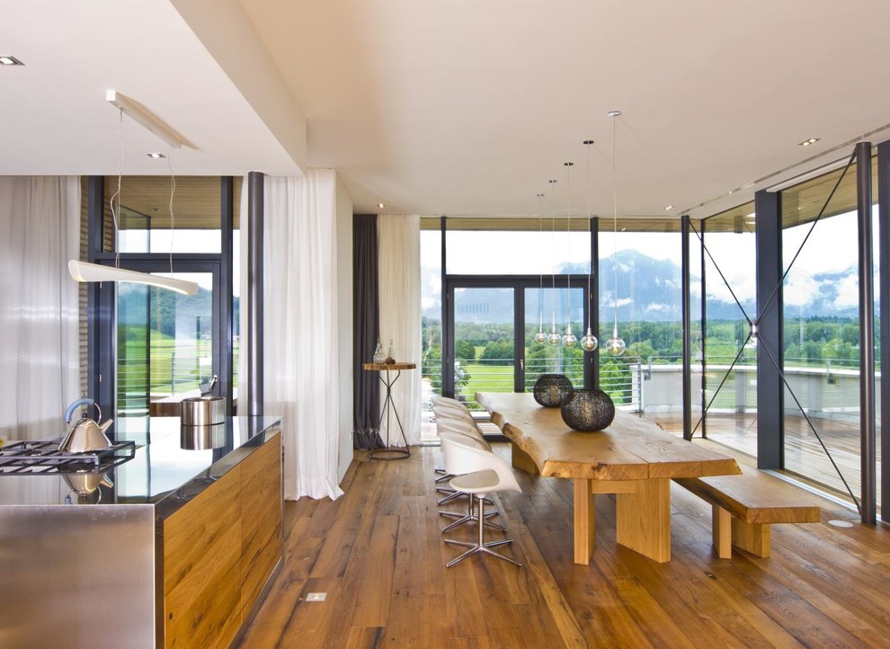 Offenes, Großes Modernes Esszimmer ohne Kamin mit braunem Holzboden und weißer Wandfarbe in Sonstige
