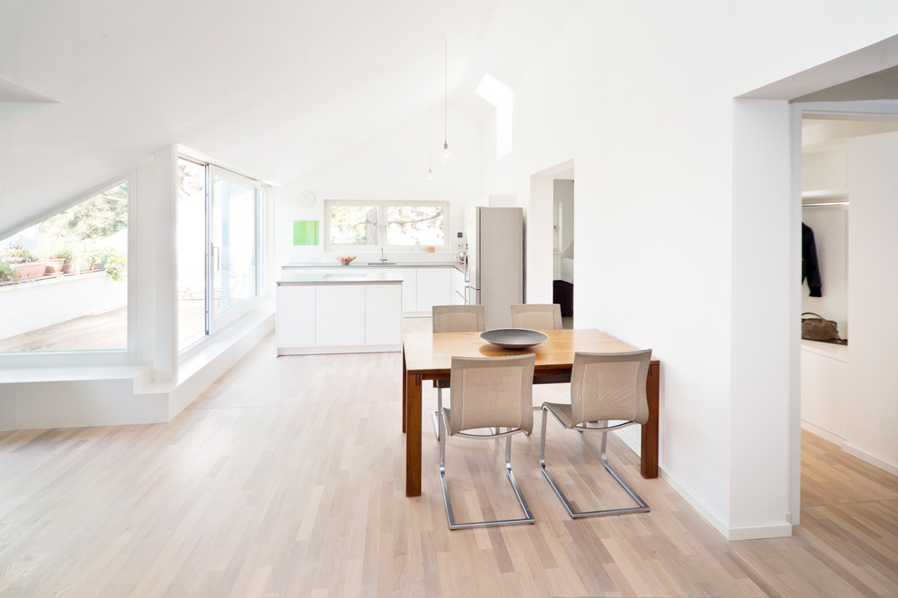 Imagen de comedor de cocina actual de tamaño medio con paredes blancas, suelo de madera en tonos medios y suelo marrón