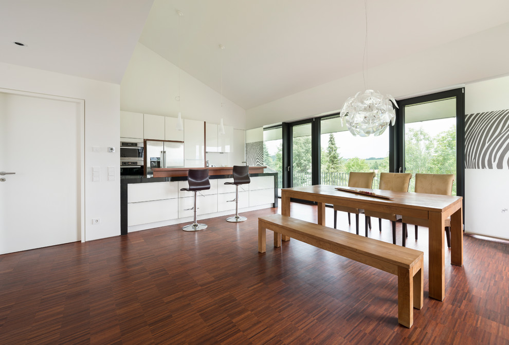 Foto di una grande sala da pranzo aperta verso il soggiorno contemporanea con pareti bianche e pavimento in legno massello medio