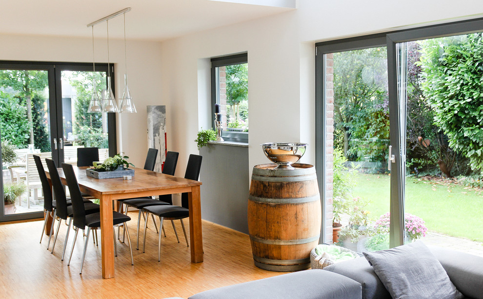 Modernes Esszimmer mit braunem Holzboden in Düsseldorf