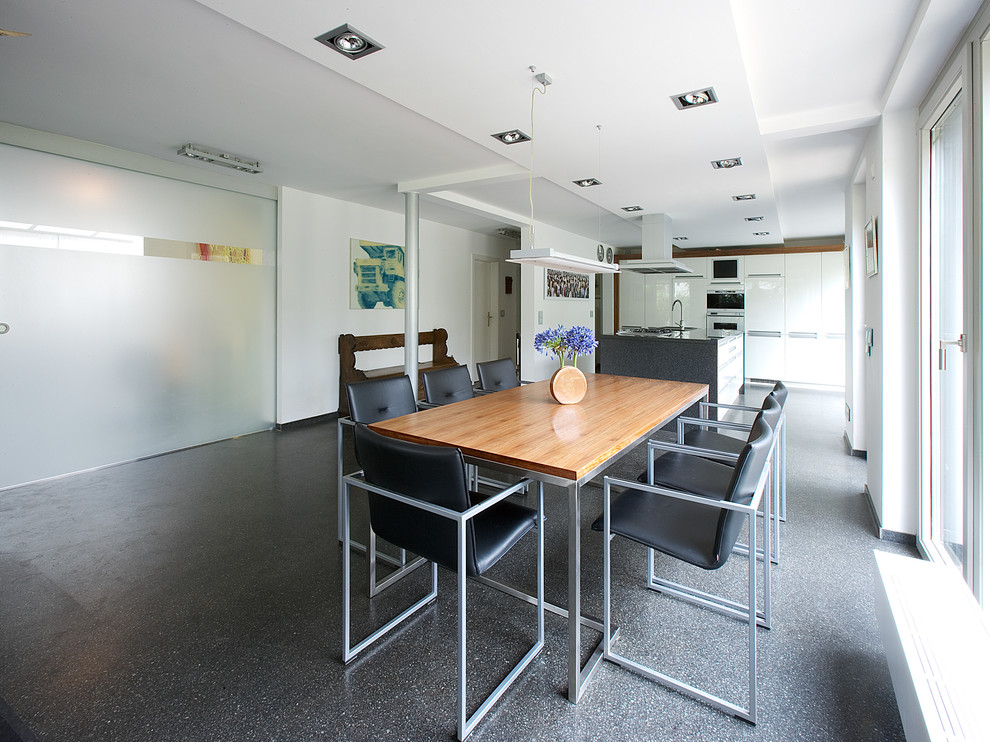 Foto di una grande sala da pranzo aperta verso la cucina design con pareti bianche