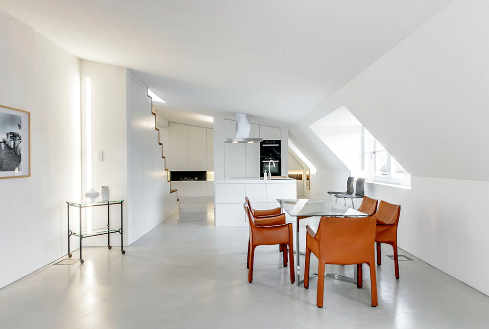 Idee per una grande sala da pranzo aperta verso la cucina minimalista con pareti bianche e pavimento in cemento