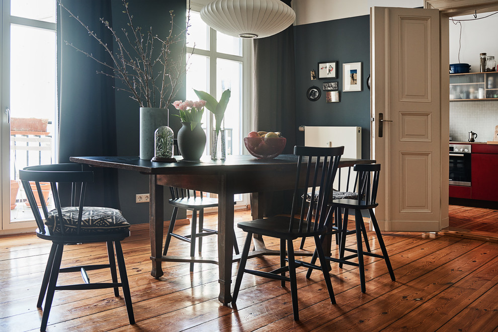 Стильный дизайн: столовая в средиземноморском стиле с синими стенами и деревянным полом без камина - последний тренд