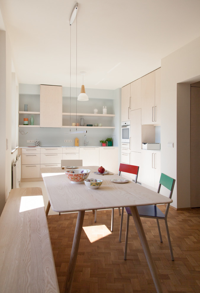 Cette photo montre une petite salle à manger ouverte sur la cuisine scandinave avec un mur beige, un sol en bois brun, aucune cheminée et un sol marron.