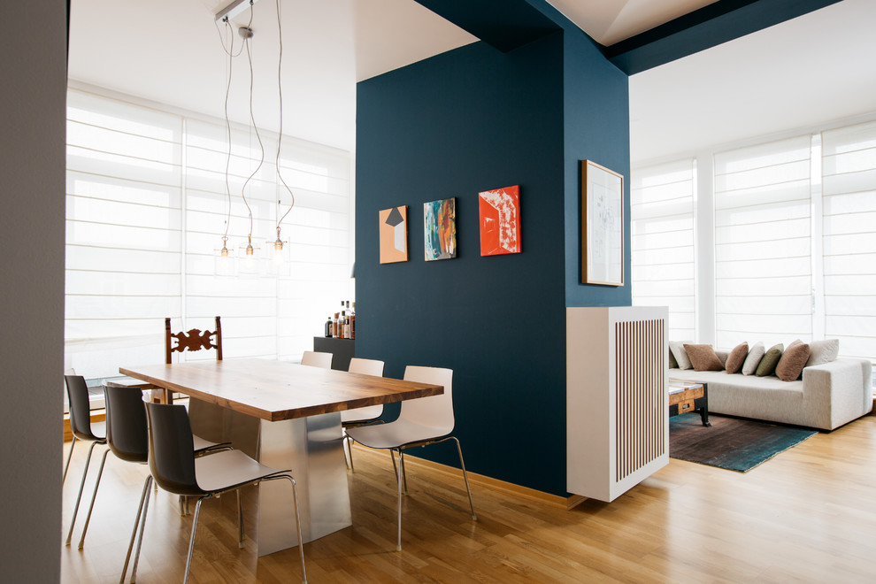 Diseño de comedor contemporáneo grande abierto sin chimenea con paredes azules, suelo de madera en tonos medios y suelo marrón