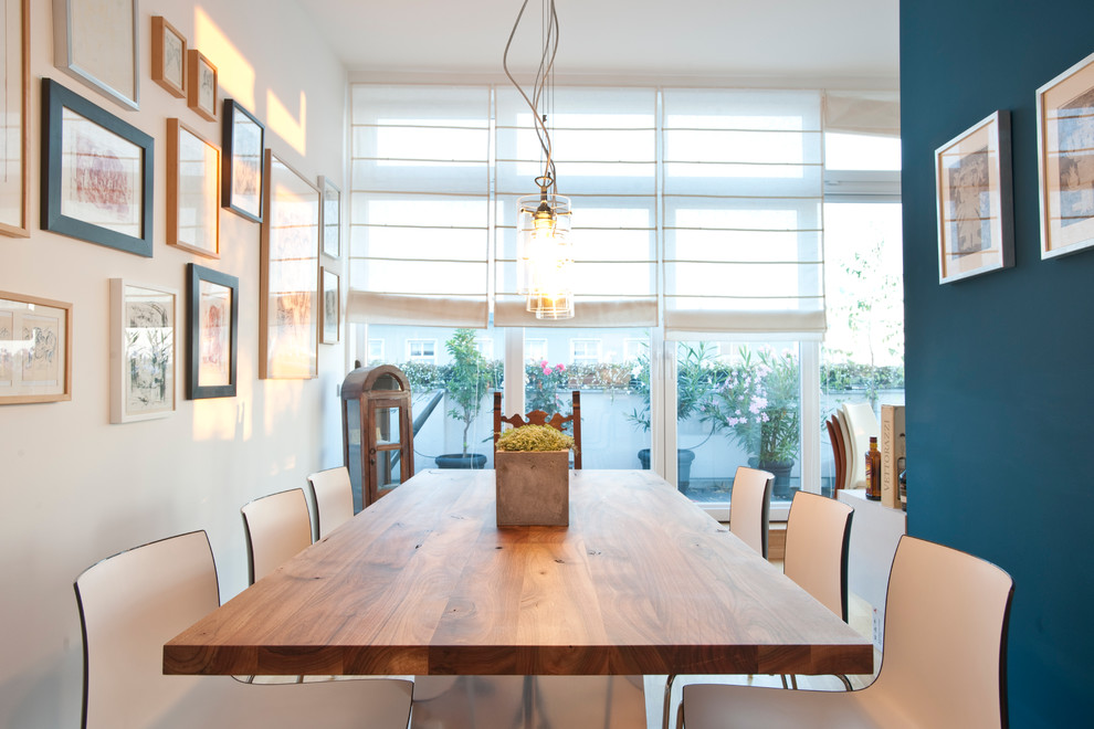 Esempio di una grande sala da pranzo aperta verso il soggiorno minimal con pareti blu, pavimento in legno massello medio e pavimento marrone