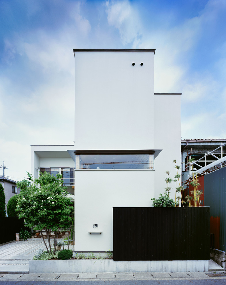 На фото: двухэтажный, белый дом среднего размера в стиле модернизм с плоской крышей с