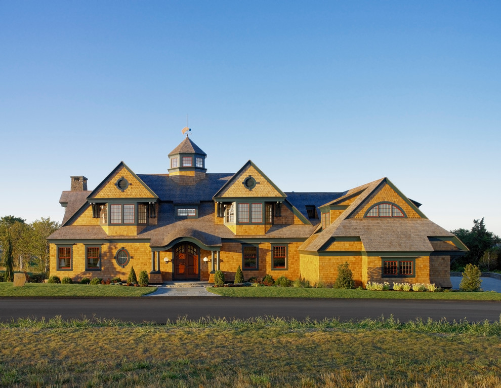 Cette photo montre une très grande façade de maison marron chic en bois à deux étages et plus.