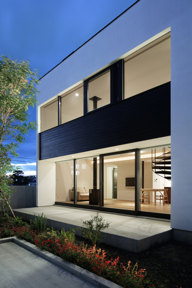 Aménagement d'une façade de maison blanche moderne de taille moyenne et à un étage avec un revêtement mixte et un toit plat.