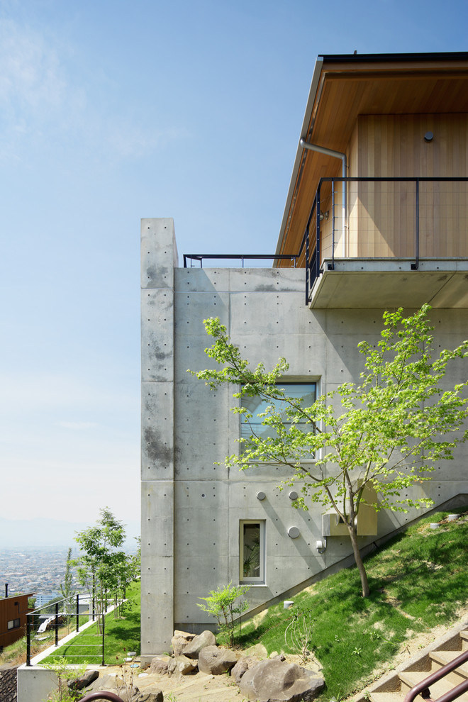 Inspiration pour une façade de maison grise design à deux étages et plus avec un revêtement mixte.