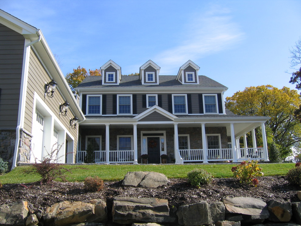 Diseño de fachada beige de estilo de casa de campo grande de dos plantas con revestimiento de piedra