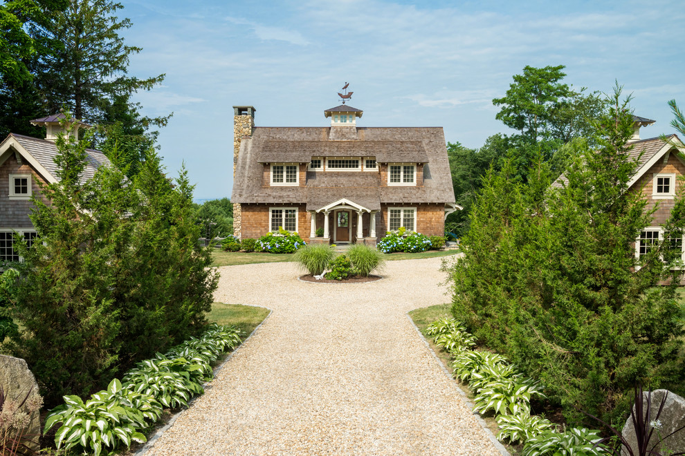 Idée de décoration pour une grande façade de maison marron marine en bois à un étage avec un toit à deux pans.