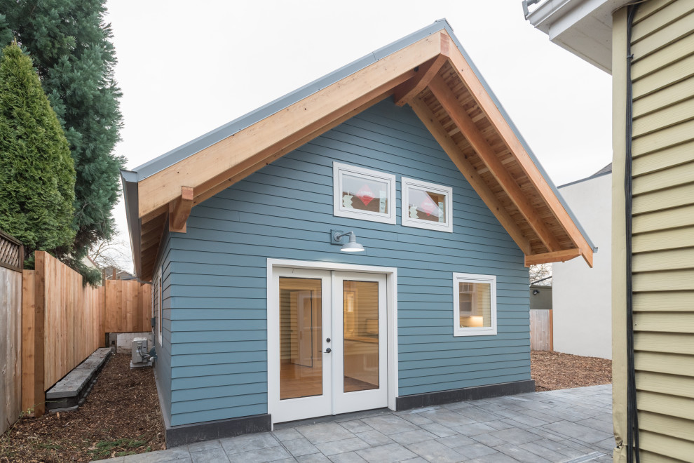 Aménagement d'une petite façade de maison bleue classique en panneau de béton fibré de plain-pied avec un toit à deux pans et un toit en métal.