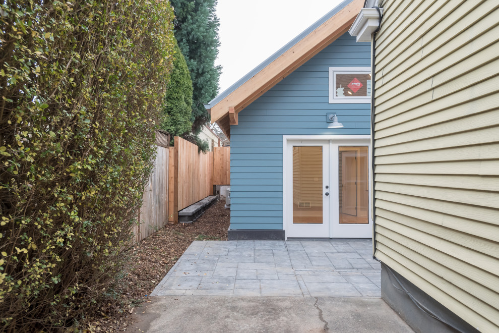 Inspiration för små klassiska blå hus, med allt i ett plan, fiberplattor i betong, sadeltak och tak i metall