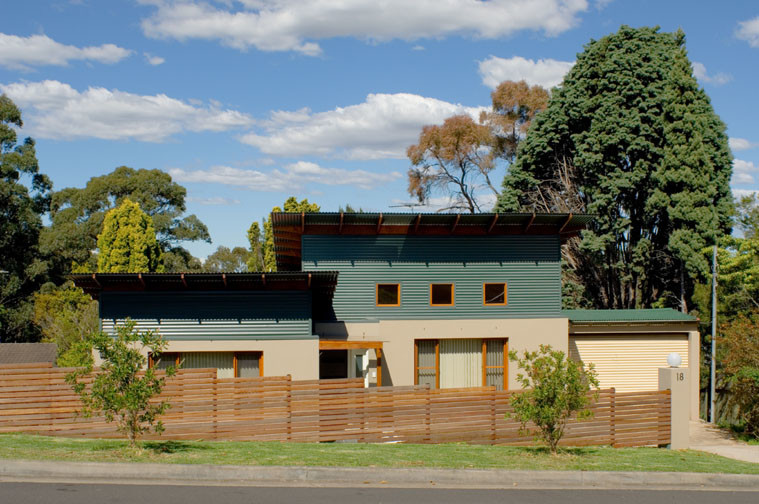 Diseño de fachada de casa multicolor actual de tamaño medio de dos plantas con revestimientos combinados y tejado de metal