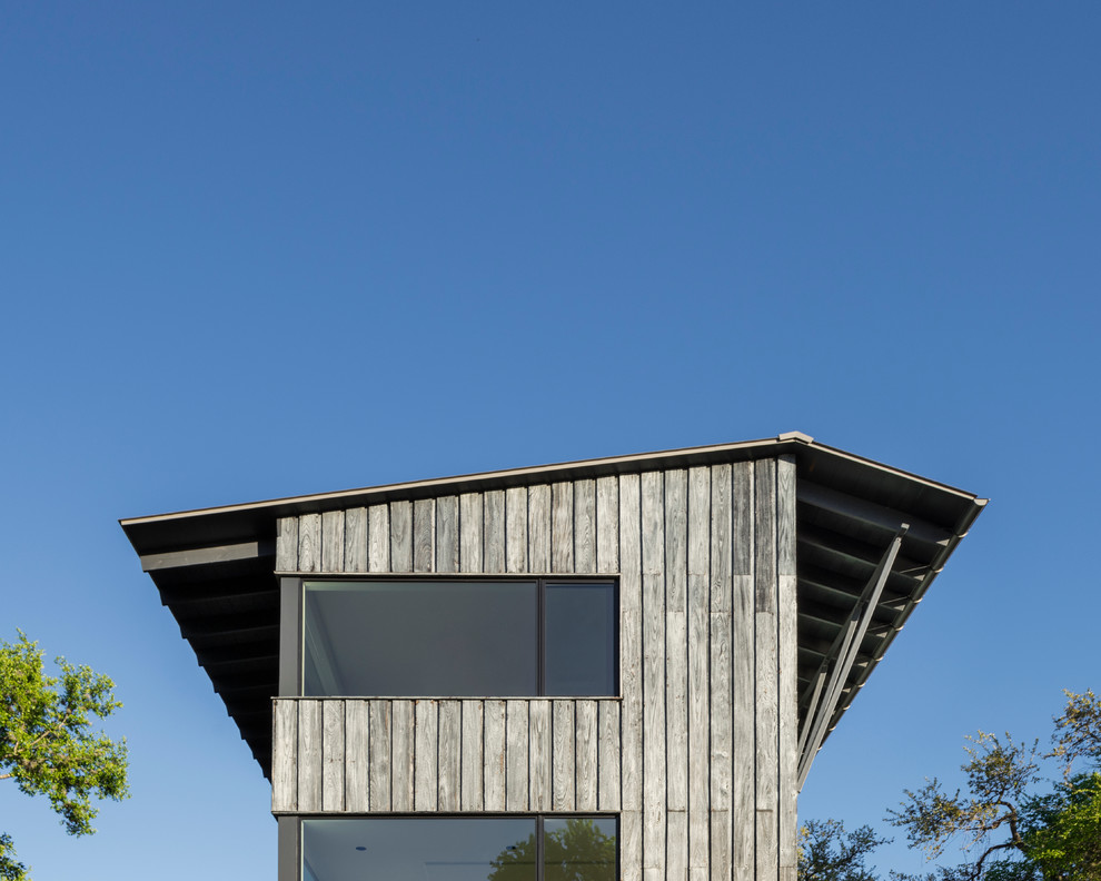 Пример оригинального дизайна: двухэтажный, деревянный, серый дом среднего размера в стиле модернизм с двускатной крышей