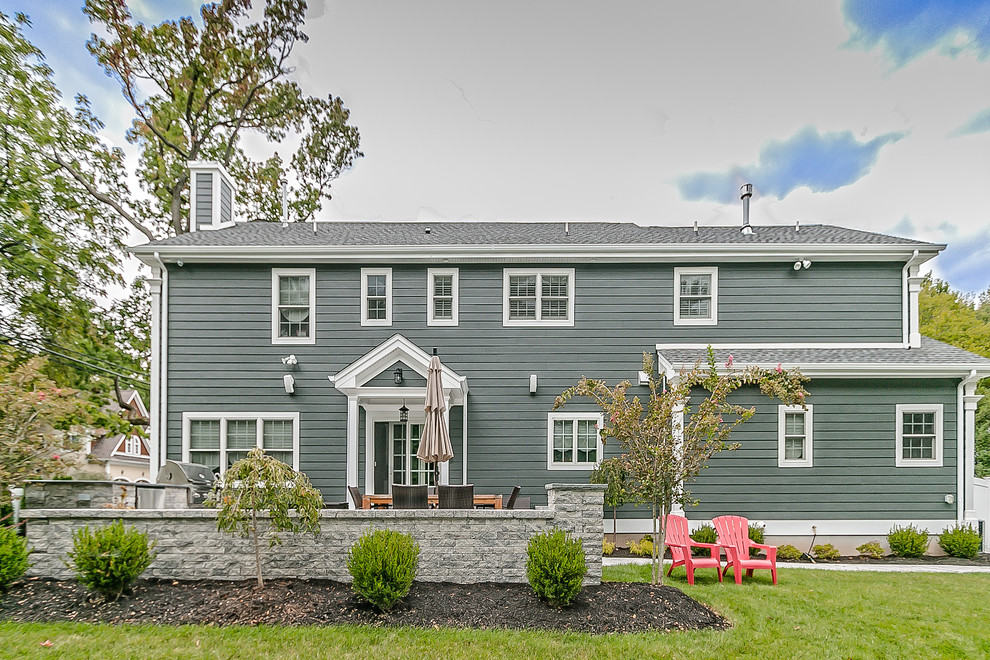 Réalisation d'une grande façade de maison grise minimaliste en bois à un étage avec un toit à deux pans.
