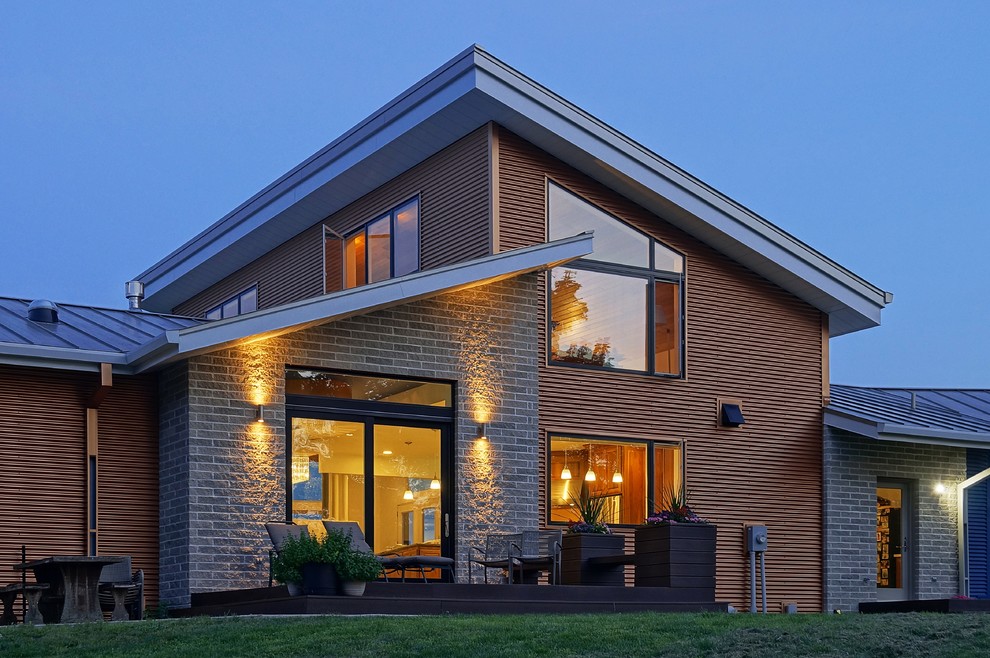 Exemple d'une façade de maison beige tendance de taille moyenne et de plain-pied avec un revêtement mixte et un toit en appentis.