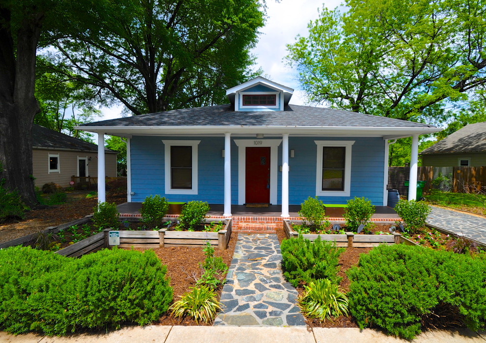На фото: маленький, одноэтажный, синий дом в классическом стиле с вальмовой крышей для на участке и в саду с