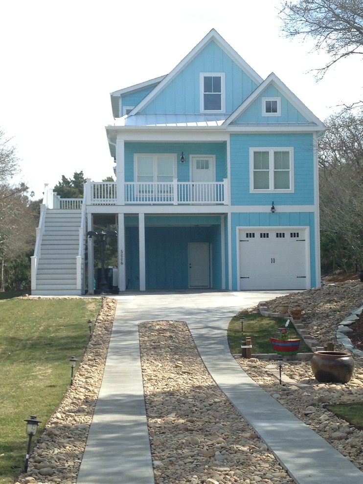 На фото: большой, двухэтажный, деревянный, синий дом в морском стиле с двускатной крышей с