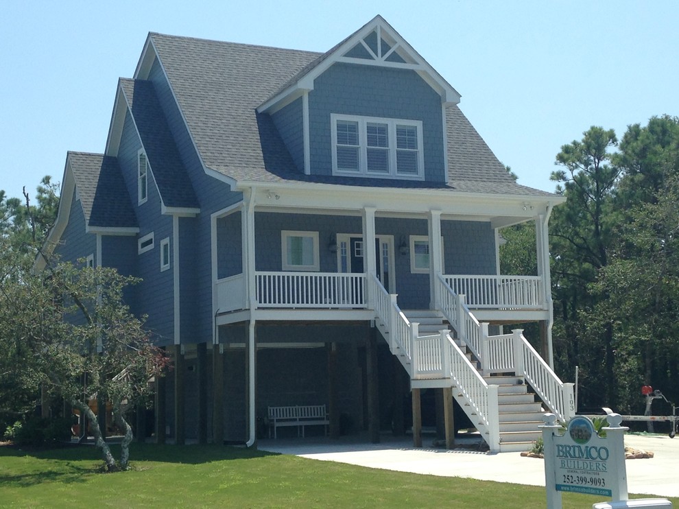 Photo of a large and blue nautical house exterior in Other with three floors, wood cladding and a pitched roof.