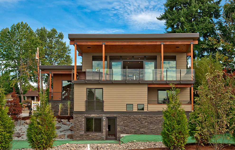 На фото: большой, трехэтажный, бежевый дом в стиле модернизм с облицовкой из камня