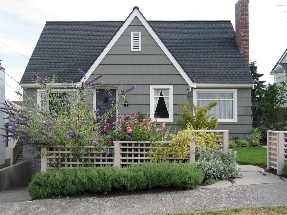 Exemple d'une façade de maison grise chic de plain-pied.