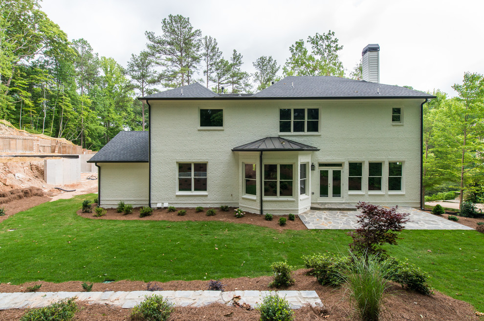 Design ideas for a large and white classic two floor brick house exterior in Atlanta with a hip roof.
