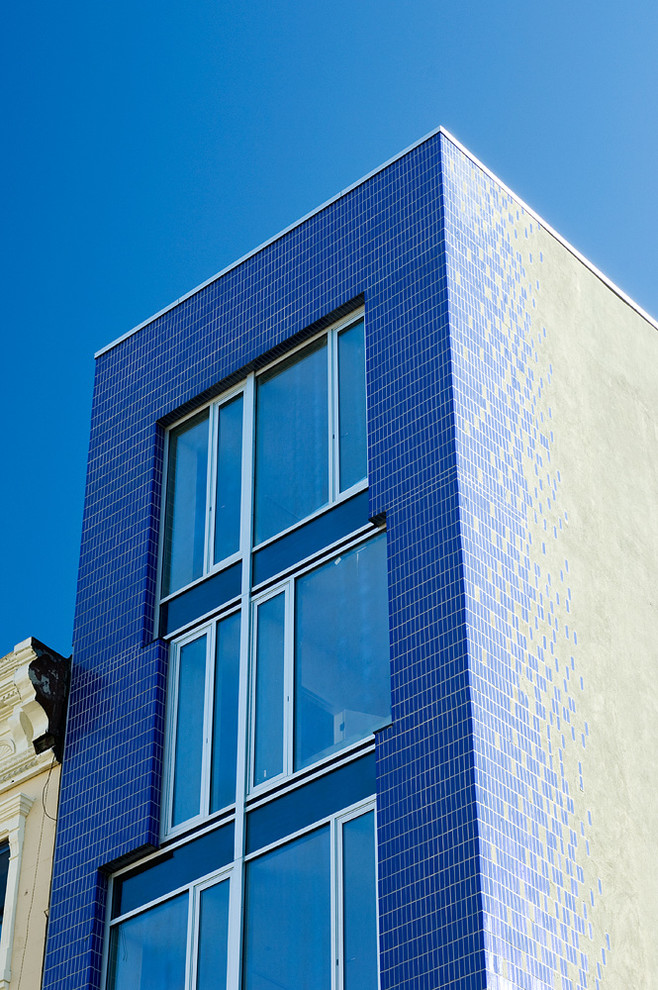 Esempio della facciata di un appartamento grande blu moderno a tre piani con rivestimenti misti e tetto piano