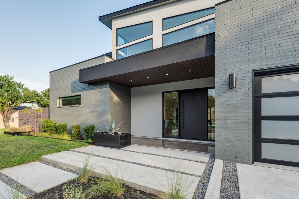 Zweistöckiges Modernes Einfamilienhaus mit Putzfassade, grauer Fassadenfarbe, Flachdach und Blechdach in Dallas