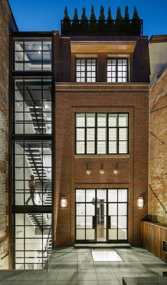 Imagen de fachada de casa pareada actual de tres plantas con revestimiento de ladrillo