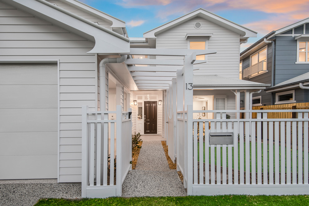 Kleines, Zweistöckiges Klassisches Haus mit weißer Fassadenfarbe, Satteldach und Blechdach in Brisbane