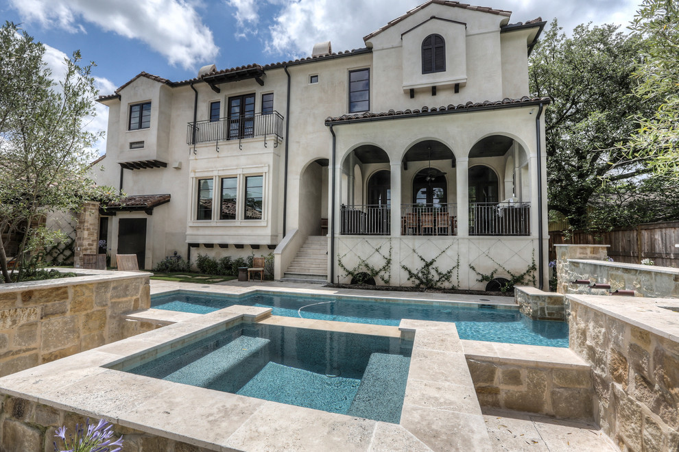 Inspiration for a large mediterranean beige two-story stucco house exterior remodel in Houston with a hip roof and a tile roof