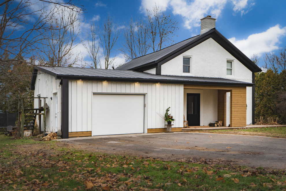 Modelo de fachada de casa blanca de estilo de casa de campo de tamaño medio de una planta con revestimientos combinados y tejado de metal