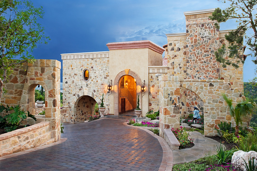 Mediterranean house exterior in Austin with stone cladding and a flat roof.