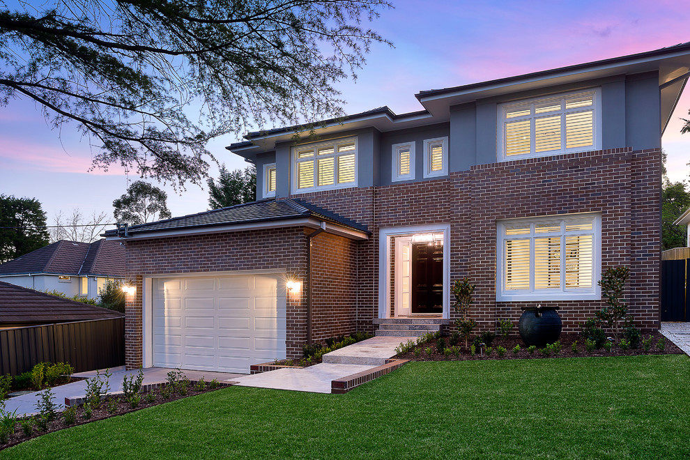 Example of a large trendy red two-story brick exterior home design in Sydney with a hip roof