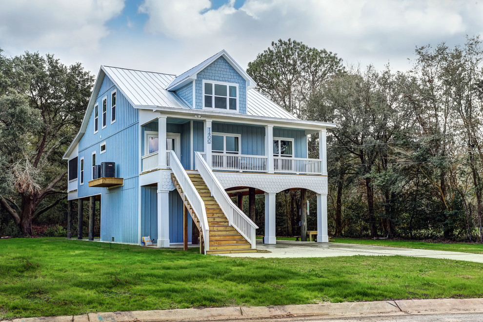 Idée de décoration pour une façade de maison bleue marine à un étage avec un revêtement mixte, un toit à deux pans et un toit en métal.