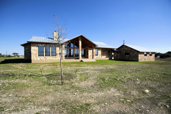 Mittelgroßes, Einstöckiges Landhaus Haus mit Steinfassade und beiger Fassadenfarbe in Austin