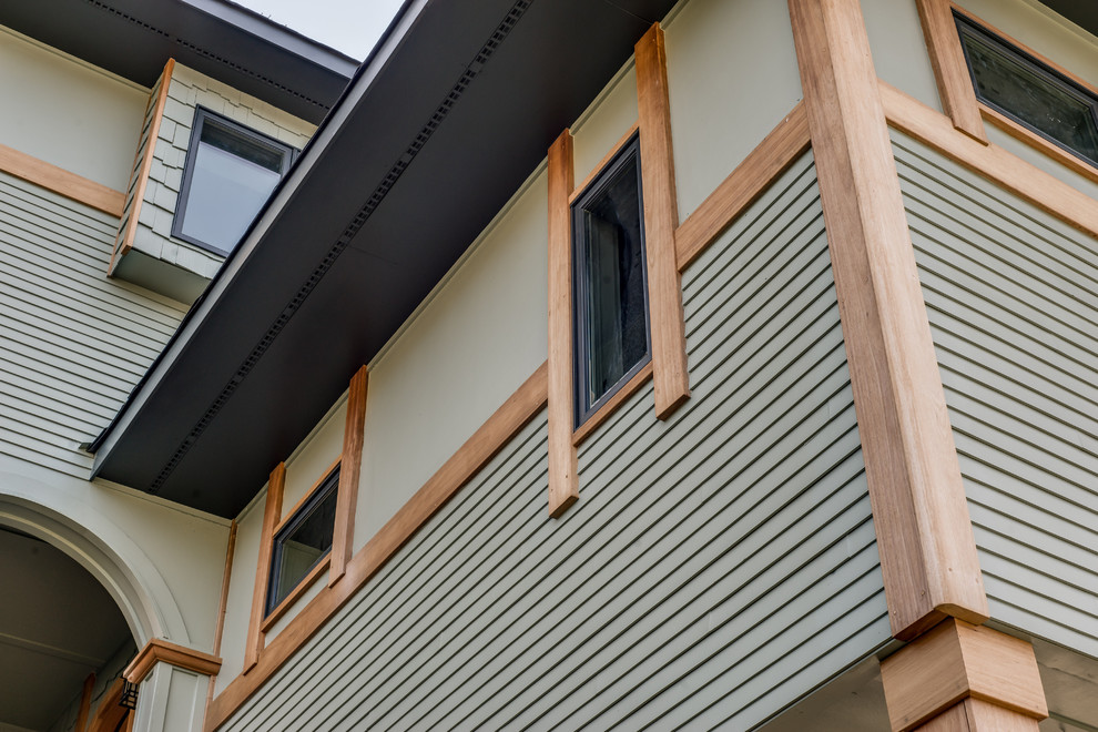 Exemple d'une façade de maison verte tendance en bois de taille moyenne et à un étage.