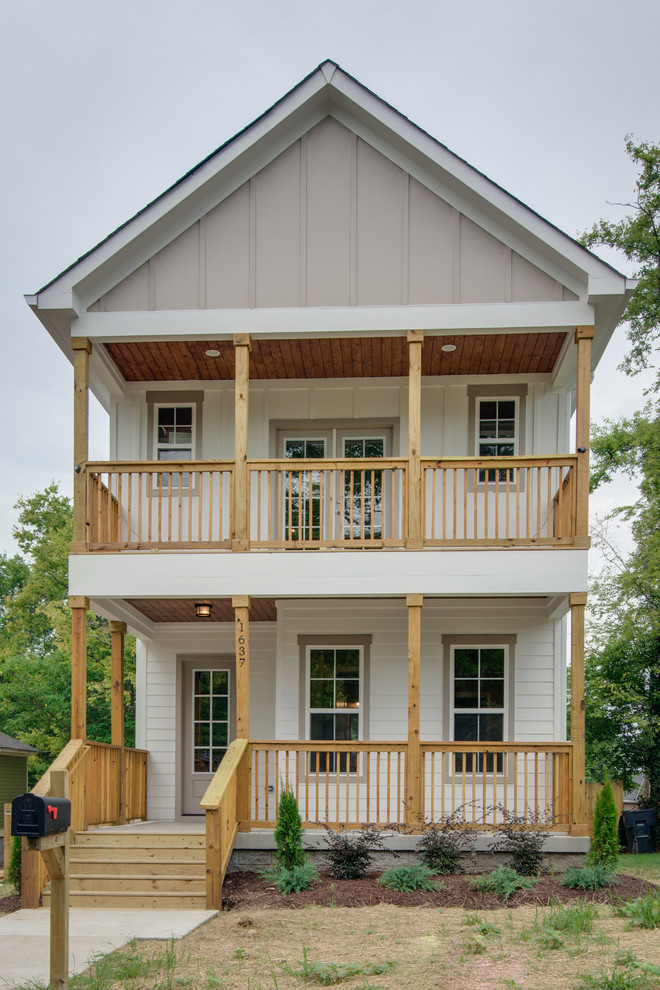 Modelo de fachada de casa blanca tradicional renovada de dos plantas con revestimiento de madera y tejado a dos aguas