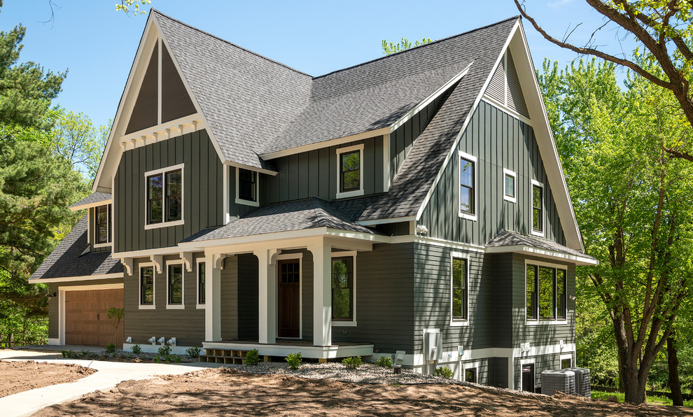 Réalisation d'une façade de maison verte tradition à un étage avec un revêtement mixte, un toit à deux pans et un toit en shingle.
