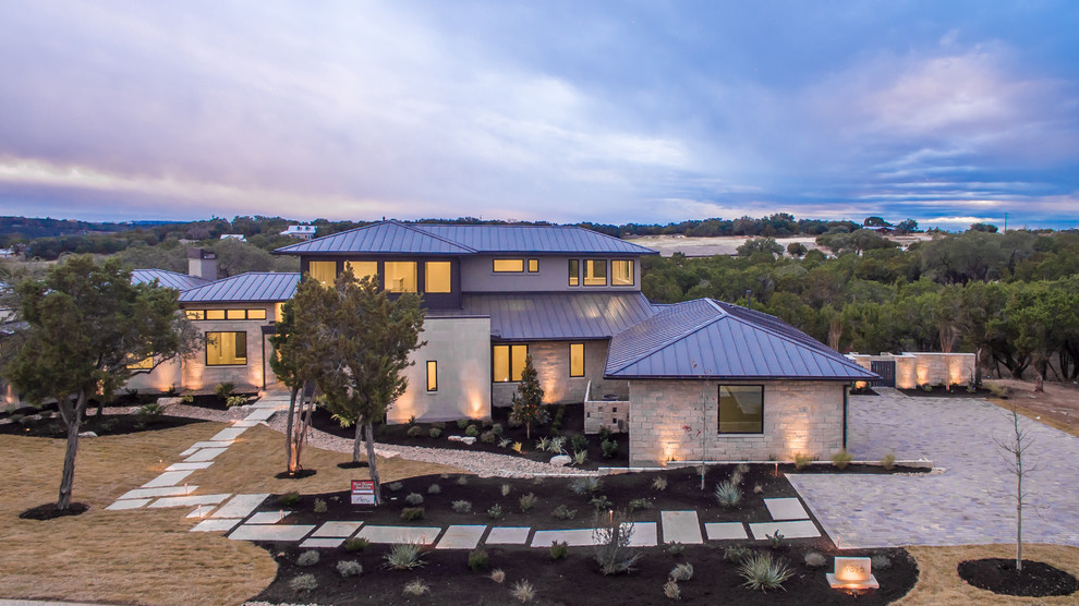 Design ideas for a large contemporary two floor house exterior in Austin with stone cladding and a hip roof.