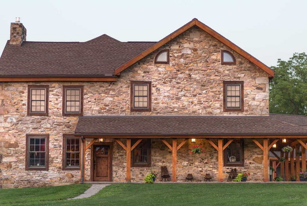 Diseño de fachada de casa marrón campestre de dos plantas con tejado a dos aguas, tejado de teja de madera y revestimiento de piedra
