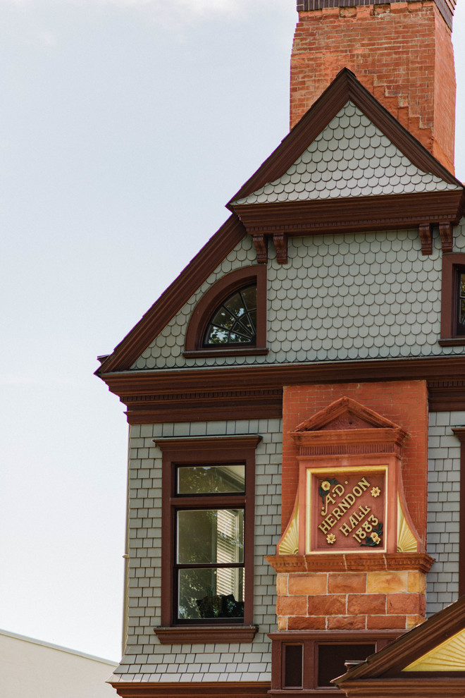 Immagine della facciata di una casa ampia grigia vittoriana a tre piani con rivestimento in legno e tetto a capanna