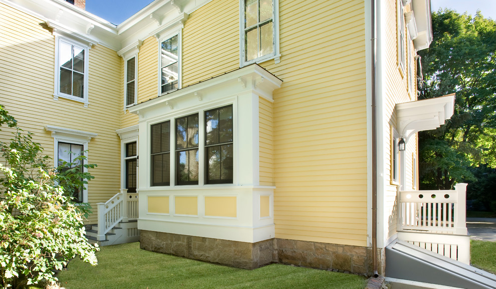 Zweistöckige Klassische Holzfassade Haus mit gelber Fassadenfarbe in Boston