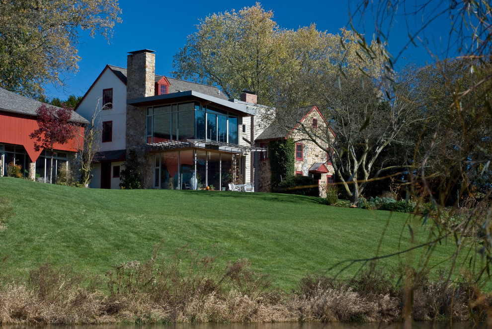 Imagen de fachada beige de estilo de casa de campo de dos plantas con revestimientos combinados y tejado a dos aguas