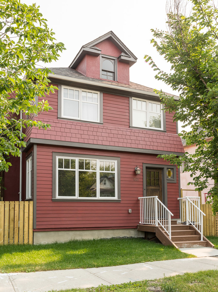 Aménagement d'une façade de maison rouge campagne de taille moyenne et à un étage avec un revêtement mixte, un toit à quatre pans et un toit en shingle.
