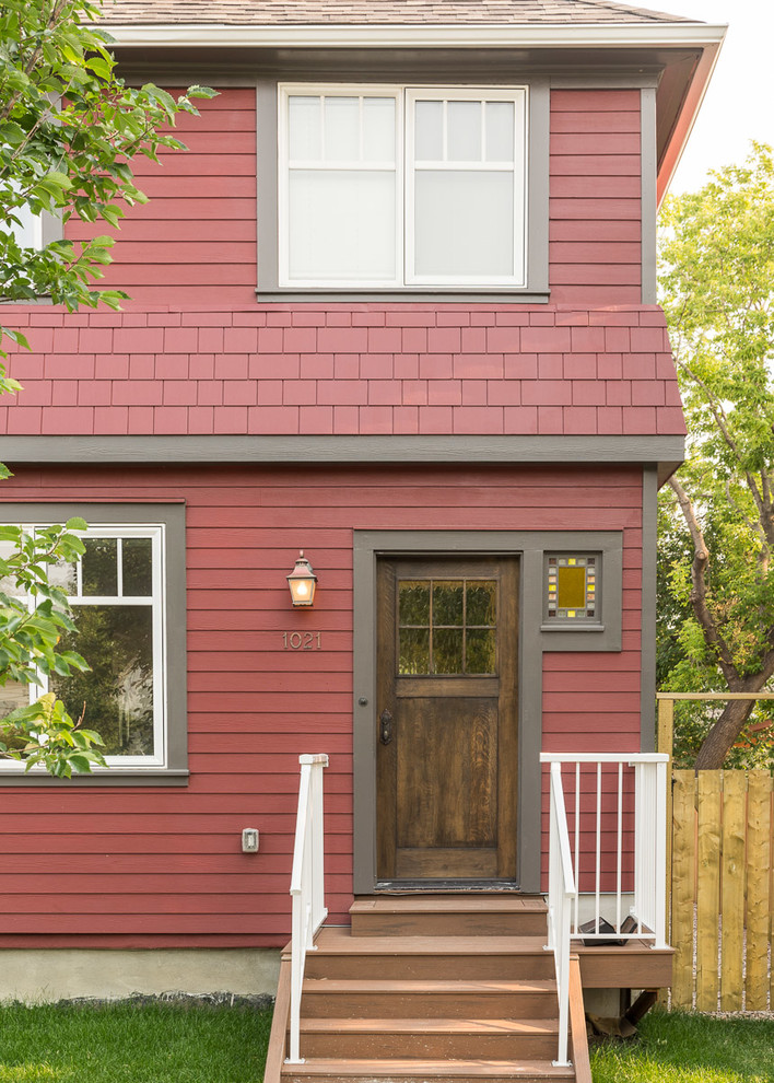 Стильный дизайн: двухэтажный, красный частный загородный дом среднего размера в стиле кантри с комбинированной облицовкой, вальмовой крышей и крышей из гибкой черепицы - последний тренд