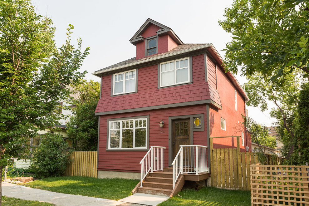 Zweistöckiges, Mittelgroßes Landhausstil Einfamilienhaus mit Mix-Fassade, roter Fassadenfarbe, Walmdach und Schindeldach in Calgary