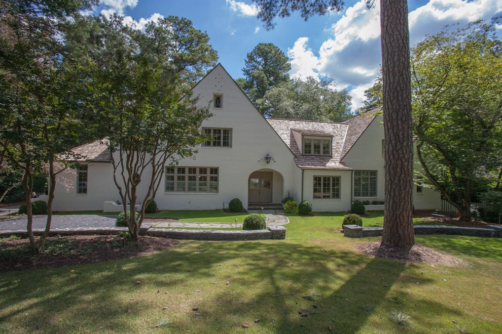 Large and white traditional two floor brick house exterior in Atlanta with a pitched roof.